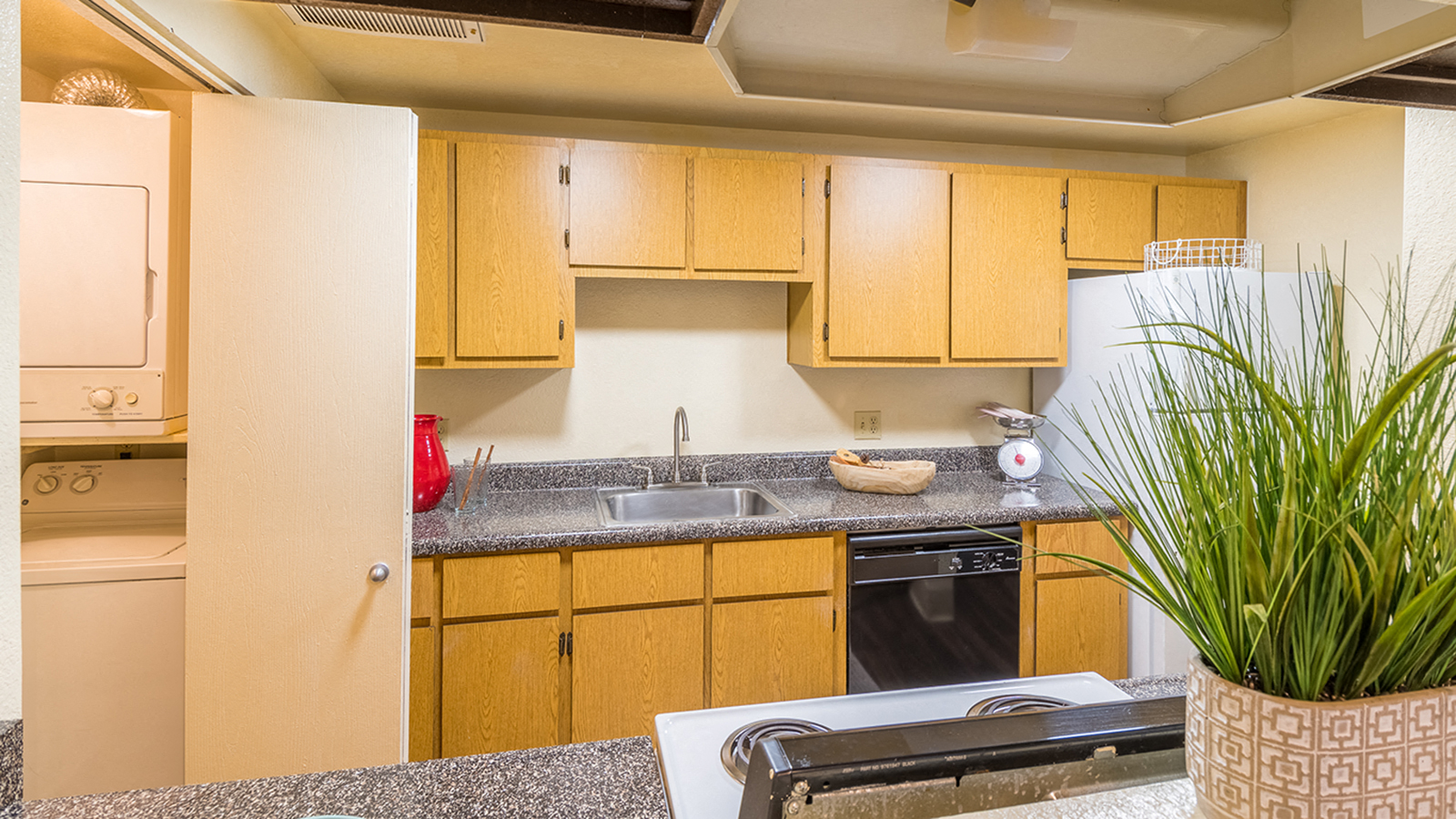 Kitchen with wood cabinets and sink next to laundry room